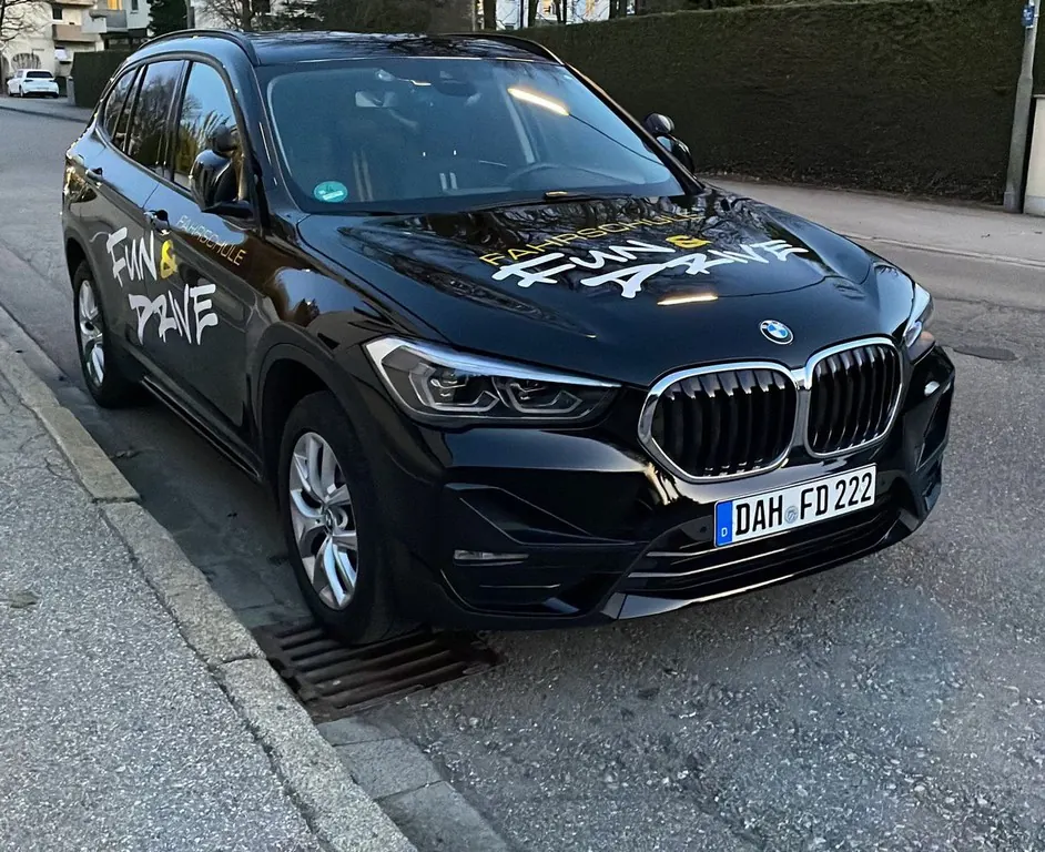 BMW X1 der Fahrschule Fun & Drive mit Fun-und-Drive-Schriftzug auf der Motorhaube