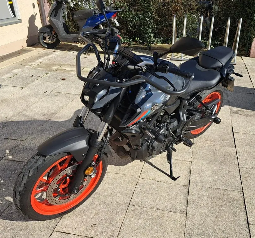 Motorrad der Fahrschule mit orangefarbenen Felgen vor der Zweigstelle
